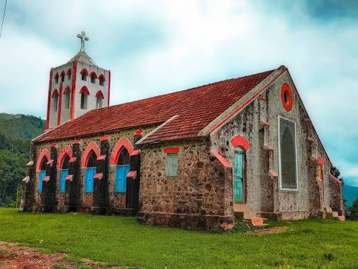 Stone church with a red-tiled roof and bell tower at Sunkarametta